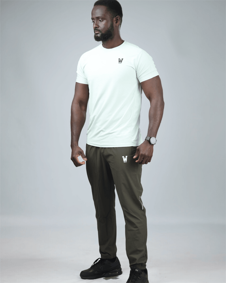 Man wearing a light green t-shirt and olive green pants on a gray background