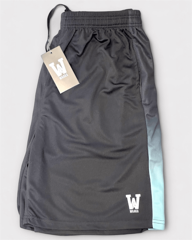 Black shorts with a gradient blue design and waaka brand tag on a light gray background