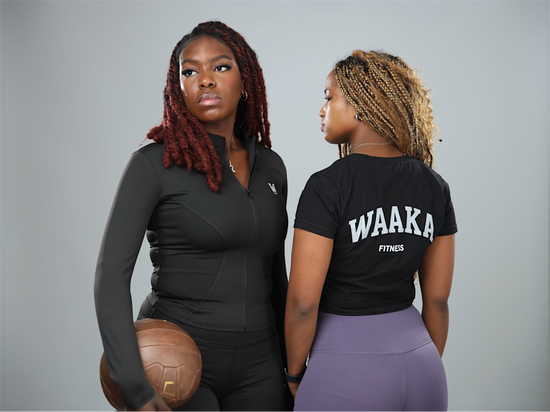Two women wearing athletic clothing with 'WAAKA' branding on a gray background