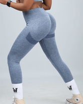 woman wearing blue activewear leggings with white socks on a light grey background