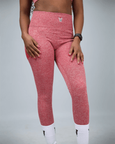 woman wearing red activewear leggings with waaka logo on a grey background