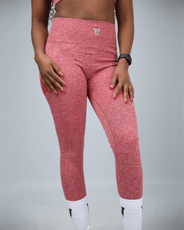 woman wearing red activewear leggings with waaka logo on a grey background
