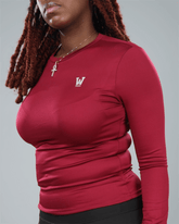 Person wearing a wine red long-sleeve shirt with waaka logo on a grey background