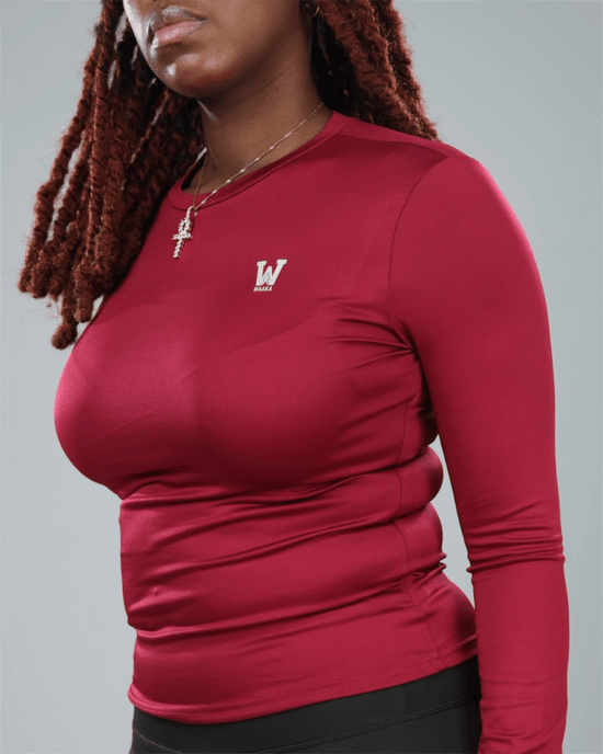 Person wearing a wine red long-sleeve shirt with waaka logo on a grey background