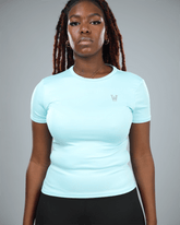 woman wearing a light blue athletic shirt with waaka logo on a grey background