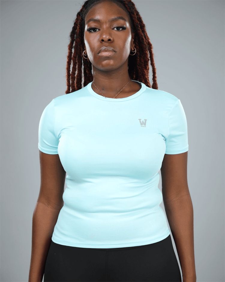 woman wearing a light blue athletic shirt with waaka logo on a grey background
