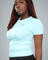 Woman wearing a light blue t-shirt with a logo on a gray background