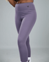 Purple leggings with waaka logo on a grey background