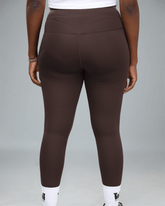 Brown leggings worn by a person on a gray background back view