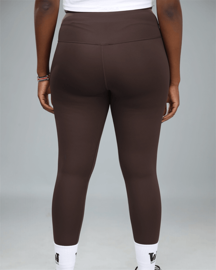 Brown leggings worn by a person on a gray background back view
