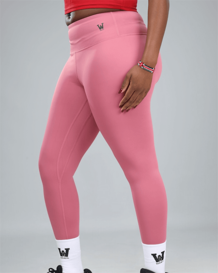 mauve Pink leggings with a logo on a grey background showing side view