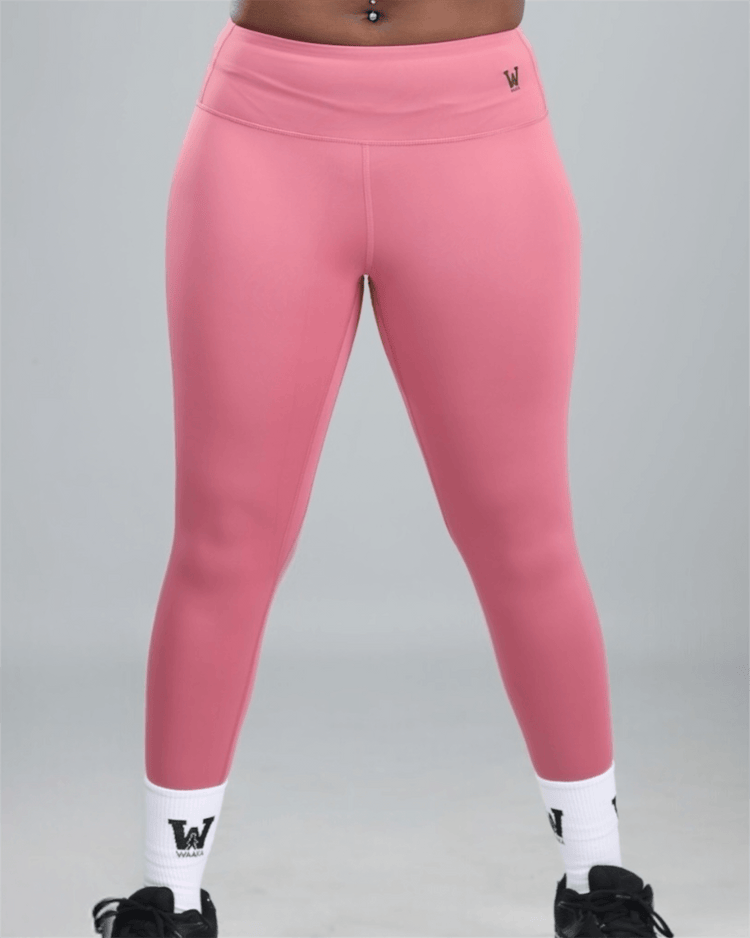 Pink leggings with white socks and black shoes on a gray background