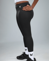 Person wearing black leggings with waaka logo on a gray background