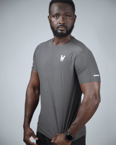 Man wearing a gray athletic t-shirt with a logo on a light gray background