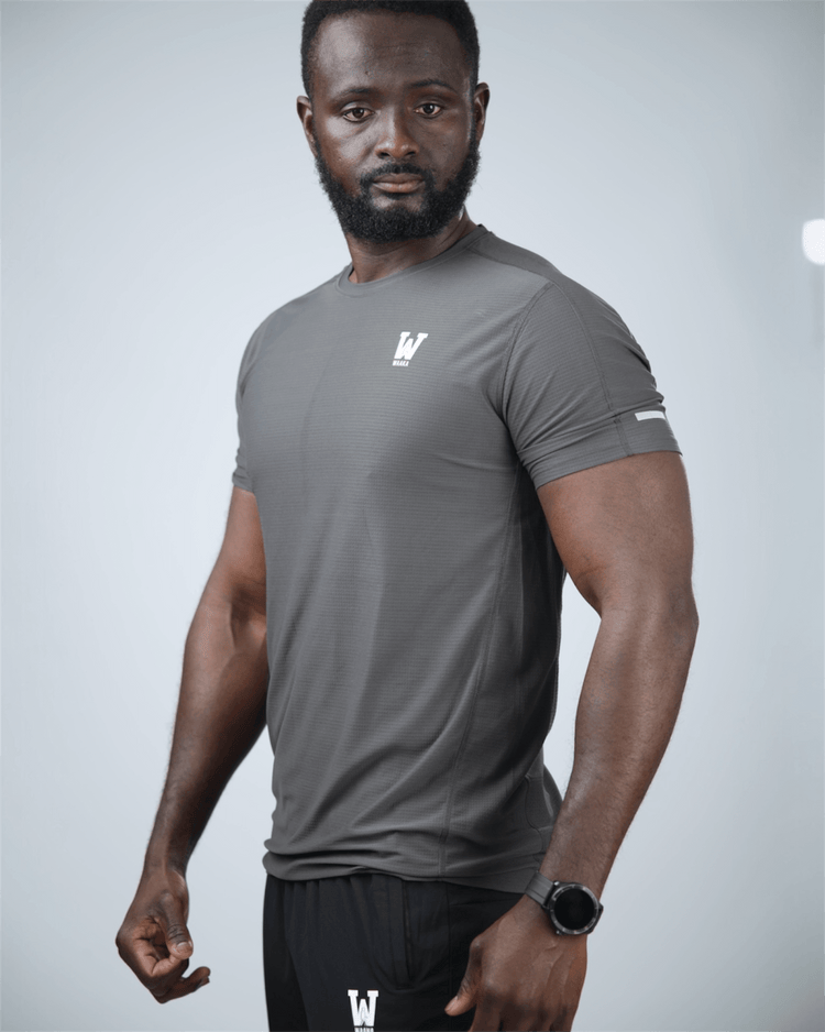 Man wearing a grey surge patterned athletic shirt with waaka logo on a light grey background