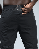 Person wearing black pants with a focus on the waist area and back pocket
