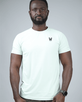 Man wearing a light green t-shirt with waaka logo on a grey background. surge patterned activewear front view