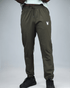 khaki green pants with waaka logo on a grey background front view. core performance pant