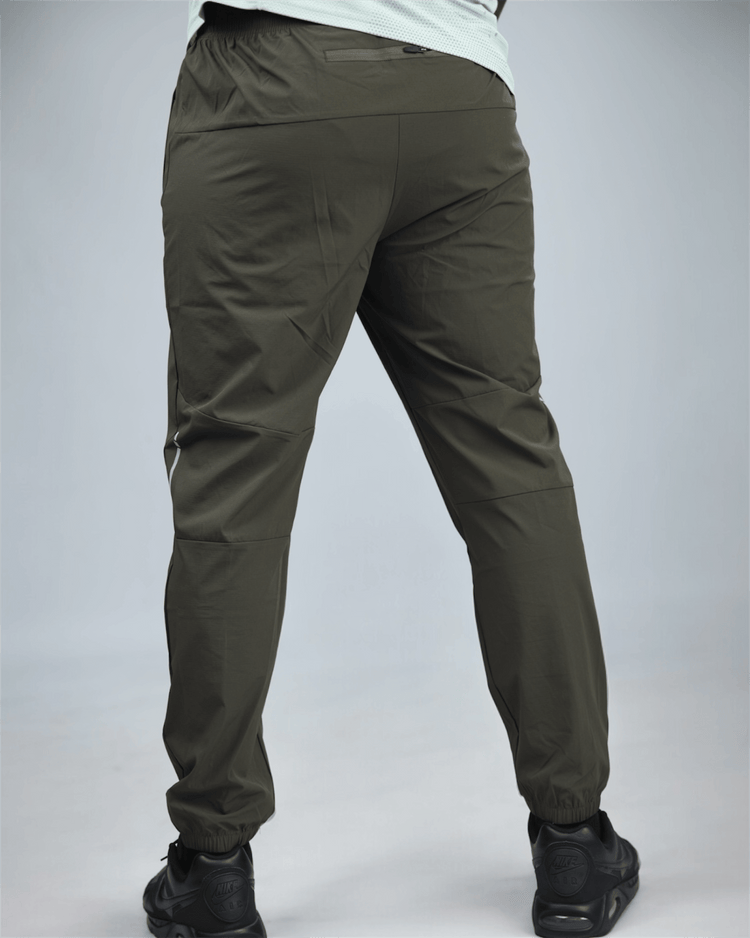 khaki green pants with waaka logo on a grey background back view. core performance pant
