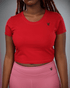 woman wearing a red crop top and pink leggings with waaka logo on a grey background