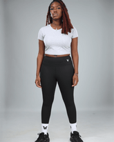 Person wearing a grey crop top t-shirt with waaka logo on a grey background full studio shot