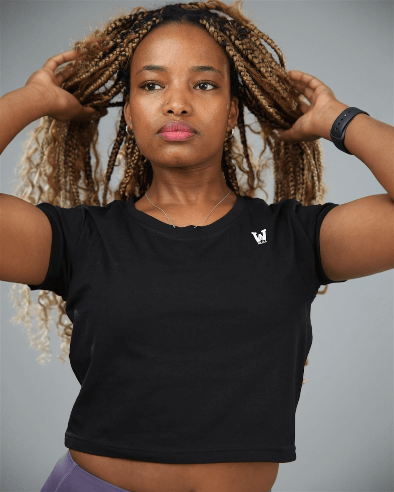 Woman wearing a black t-shirt with a logo on a gray background