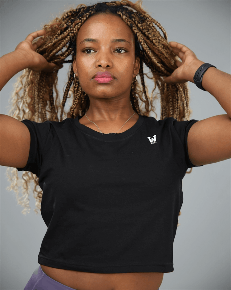Woman wearing a black t-shirt with a logo on a gray background