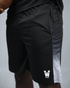 Black eco training athletic shorts with a white waaka logo on a grey background