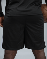 Person wearing black shorts with a blurred background back view