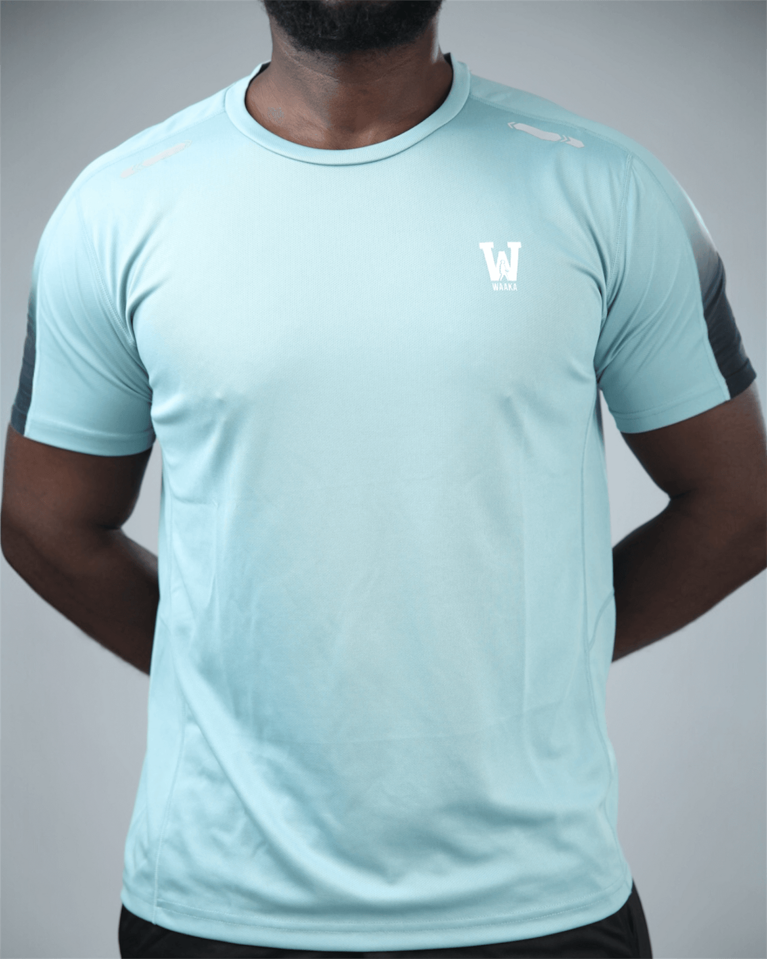Light blue athletic shirt with waaka logo on a gray background