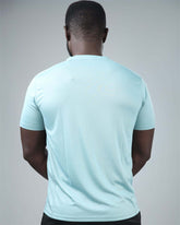 Person wearing a light blue t-shirt on a gray background back view