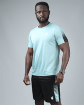 Man wearing a light blue athletic shirt and black shorts on a gray background