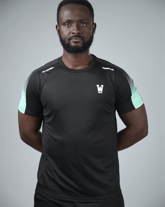 Man wearing a black athletic outfit with waaka logo on a grey studio background