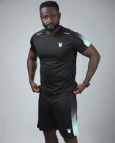Man wearing a black athletic waaka logo outfit with green accents on a grey background