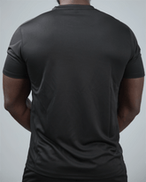 Person wearing a plain black t-shirt on a light gray background