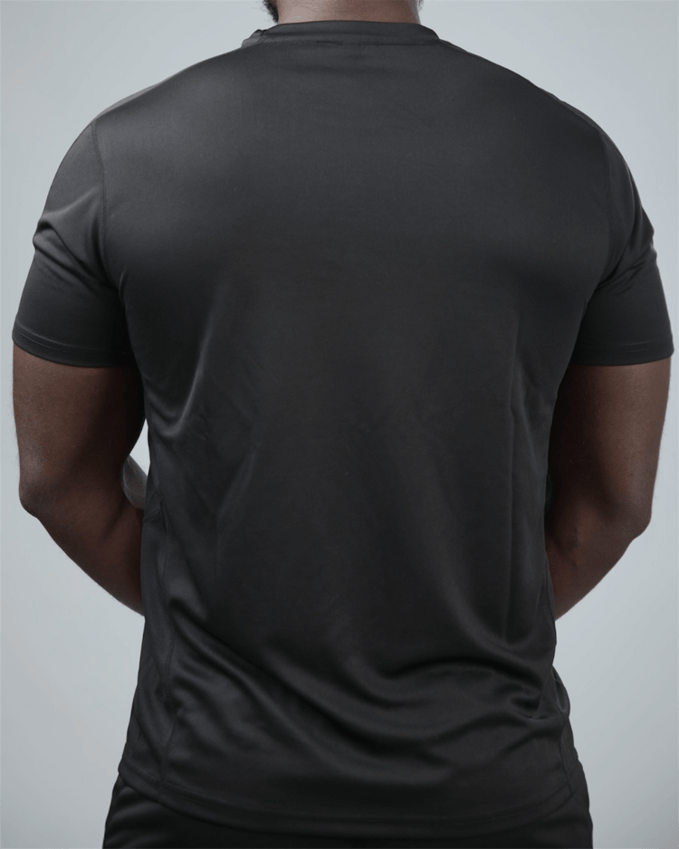 Person wearing a plain black t-shirt on a light gray background