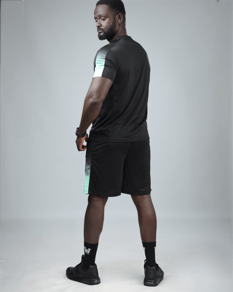 Man wearing a black athletic outfit with a gray background back view