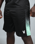 Black eco training shorts with waaka logo an green accents on a grey background