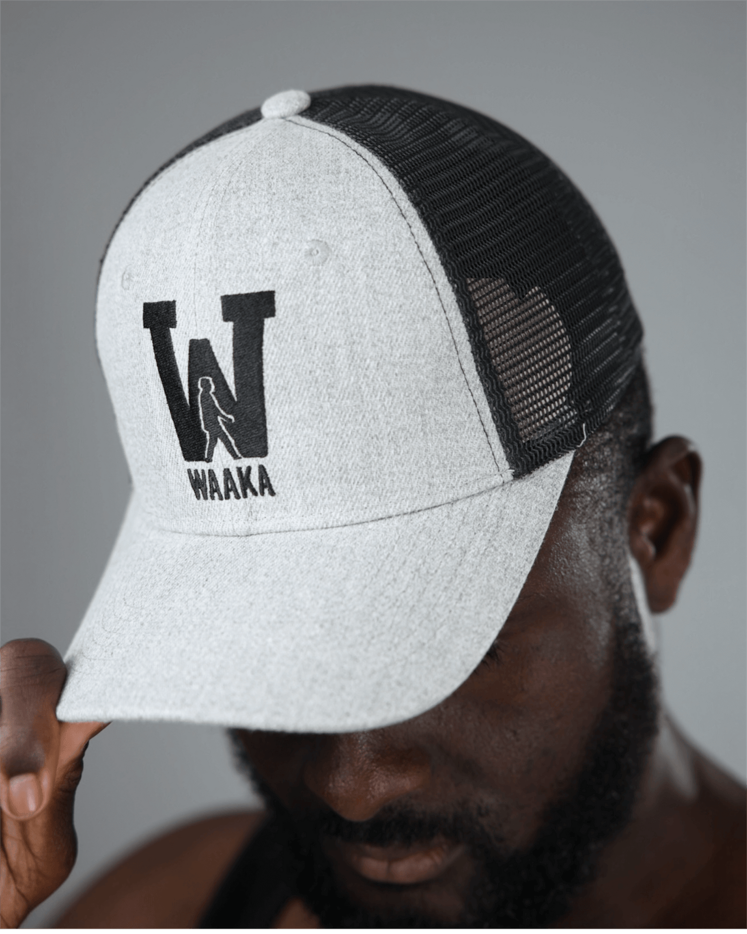 Person wearing a light gray and black mesh cap with &