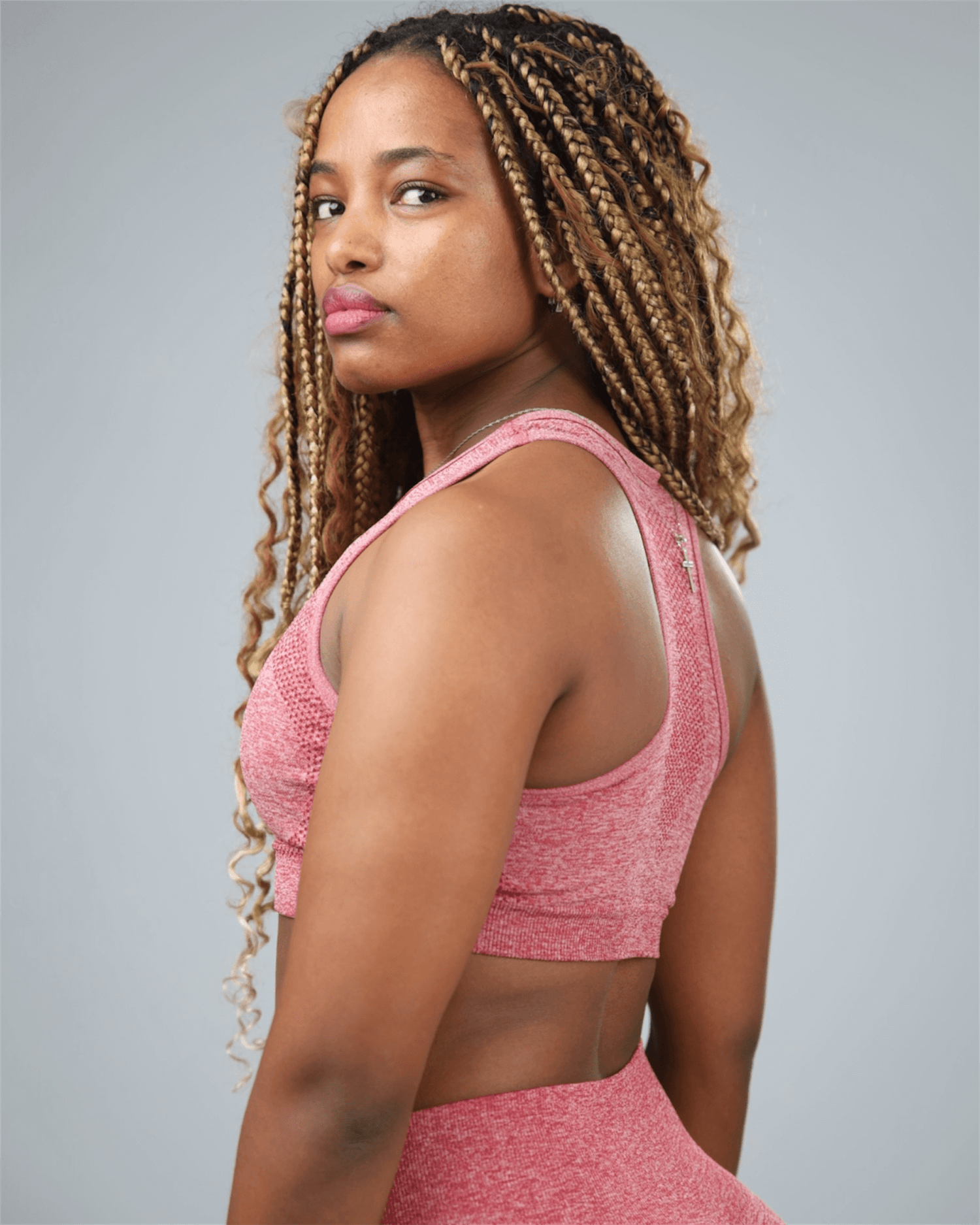Woman wearing a red athletic outfit against a gray background