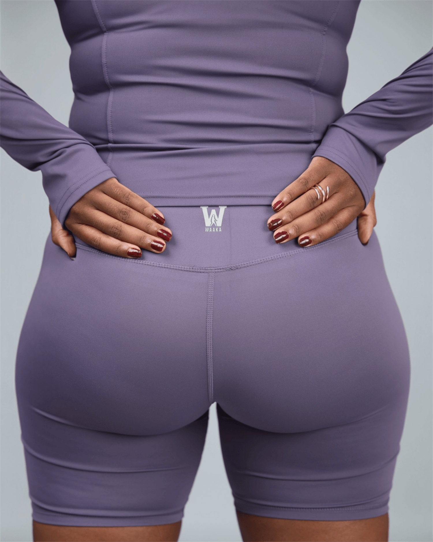 Purple athletic outfit with a logo on a plain background back view