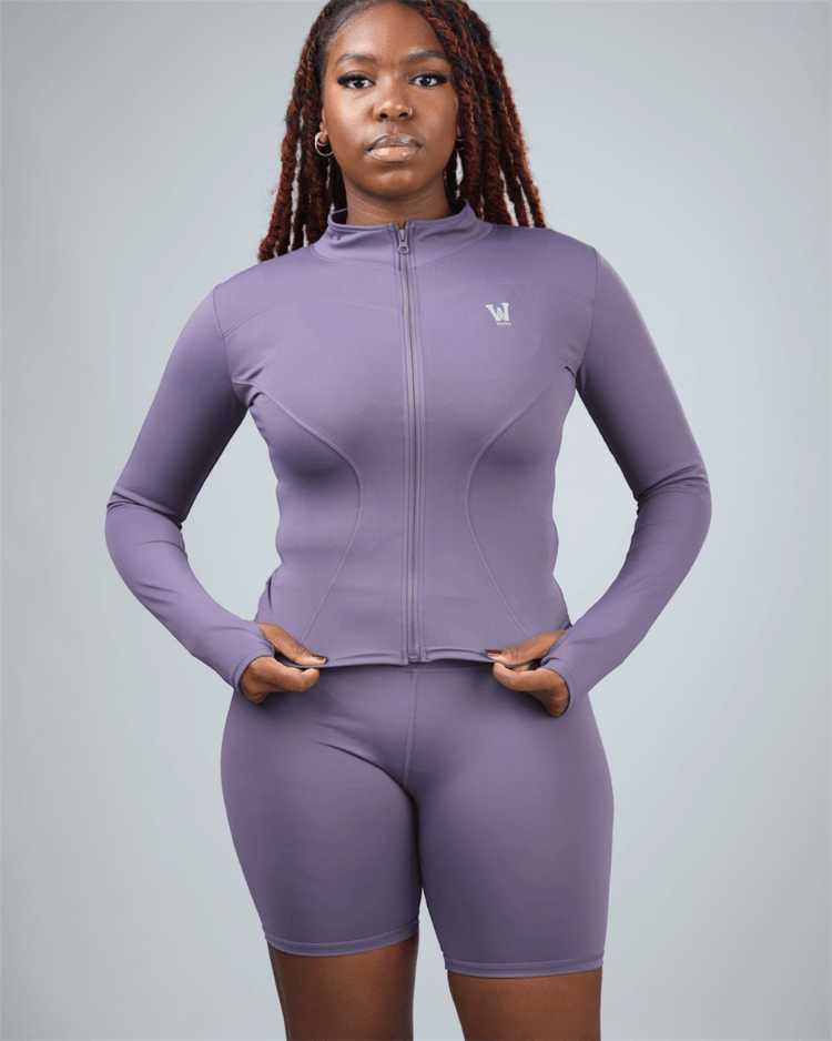 Person wearing a purple athletic outfit with a logo on a gray background