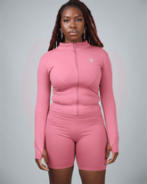 Person wearing a pink athletic outfit with a logo on a gray background