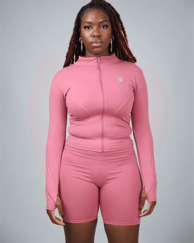 Person wearing a pink athletic outfit with a logo on a gray background