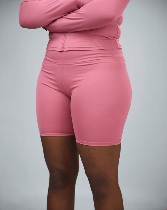 Person wearing pink ignite active shorts on a grey background