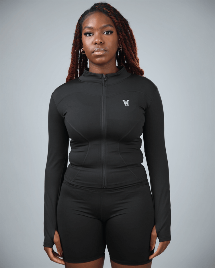 Person wearing a black athletic outfit with a logo on a gray background