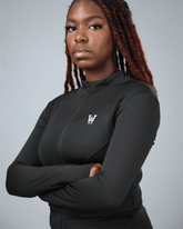 Person wearing a black athletic jacket with waaka logo on a gray background